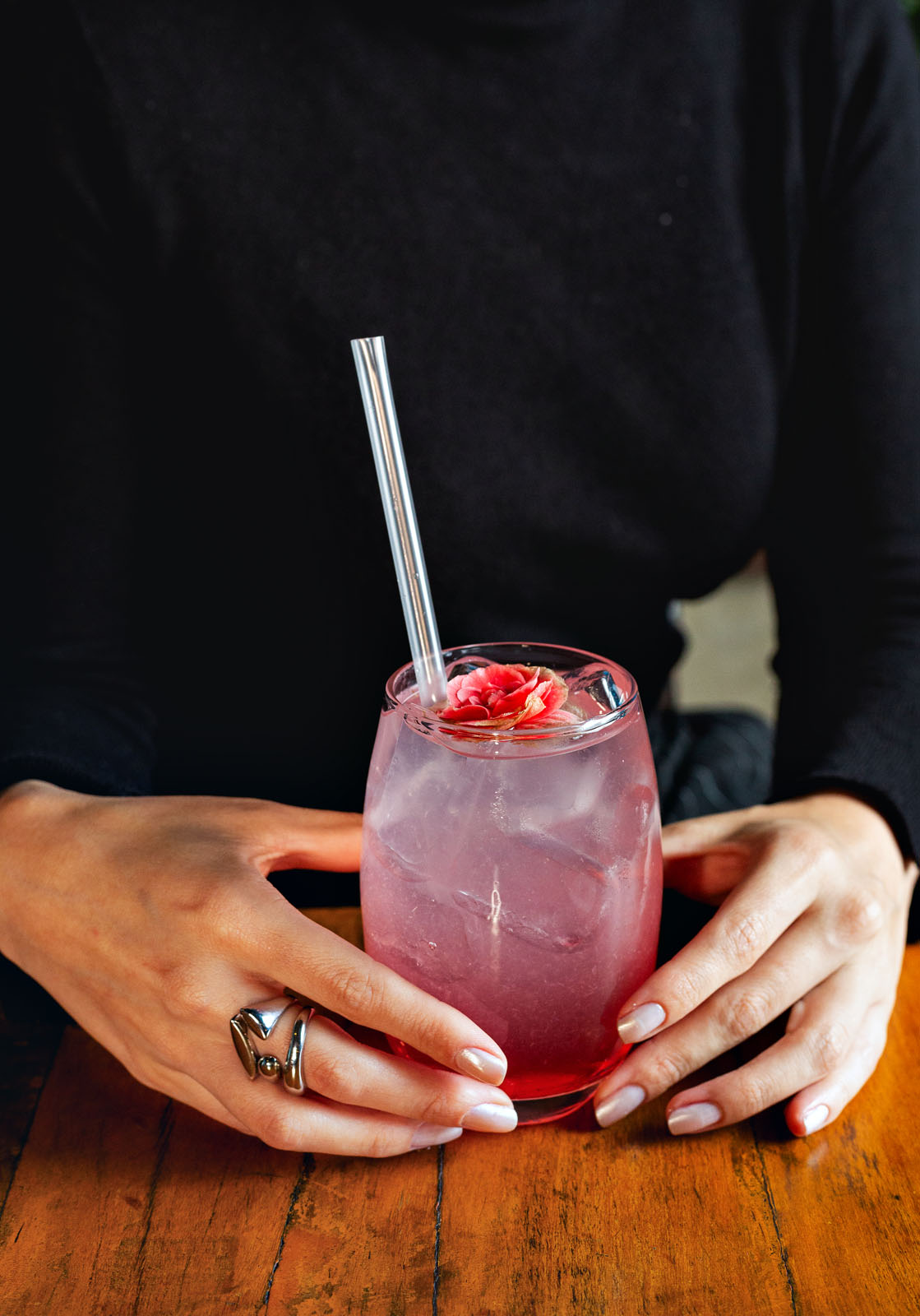 Drink rosado em mãos
